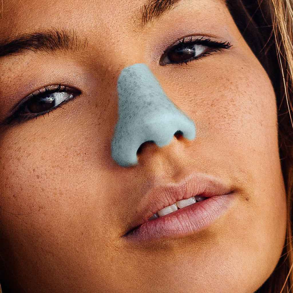 Young woman with Noz sun protection on her nose in seafoam